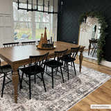 Farmhouse dining room with a gray Bevin Washable Area Rug, wood table, black chairs, and black herringbone accent wall. Roomscene-Rectangle
