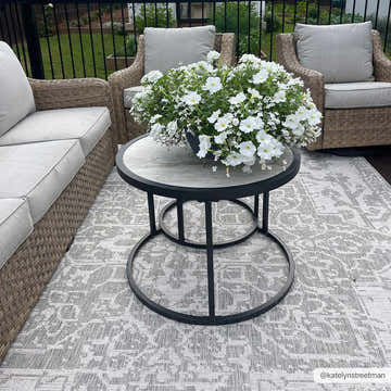 Outdoor patio scene with gray wicker furniture and Beige Kilmacolm Outdoor Rug. The rug has a traditional oriental pattern. Roomscene-Rectangle