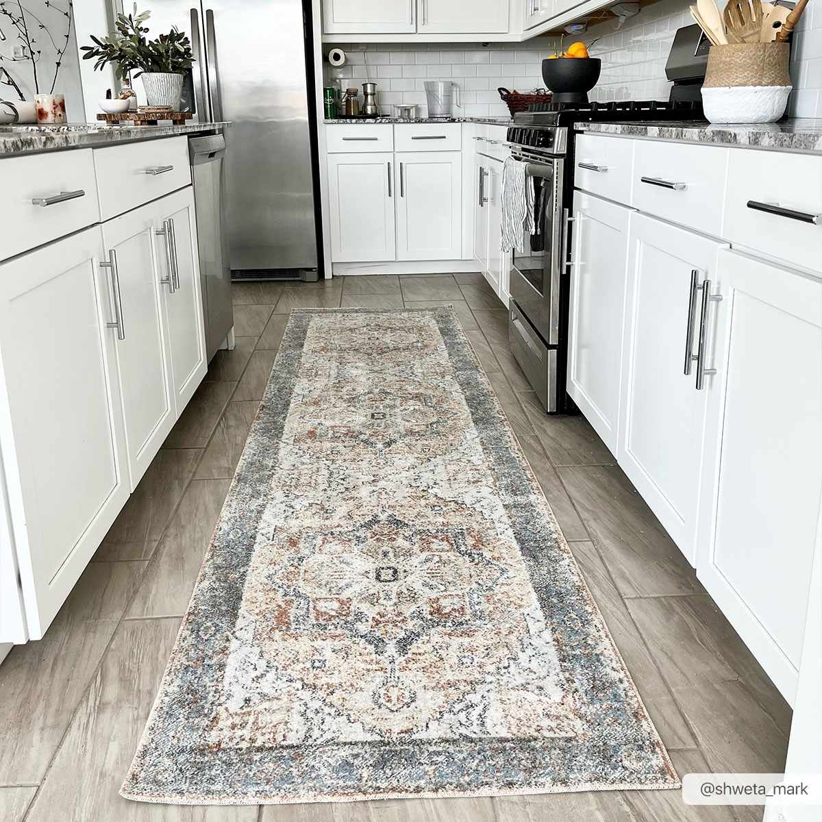 Bright kitchen scene with a Blue Orange Hera Washable rug runner between white cabinets and wood-look tile. Roomscene-Runner