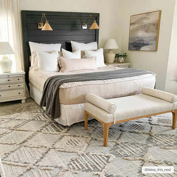 Bedroom scene with a Bogtong High-Low Rustic Rug in charcoal, cream, and gray under a bed and bench. Roomscene-Rectangle