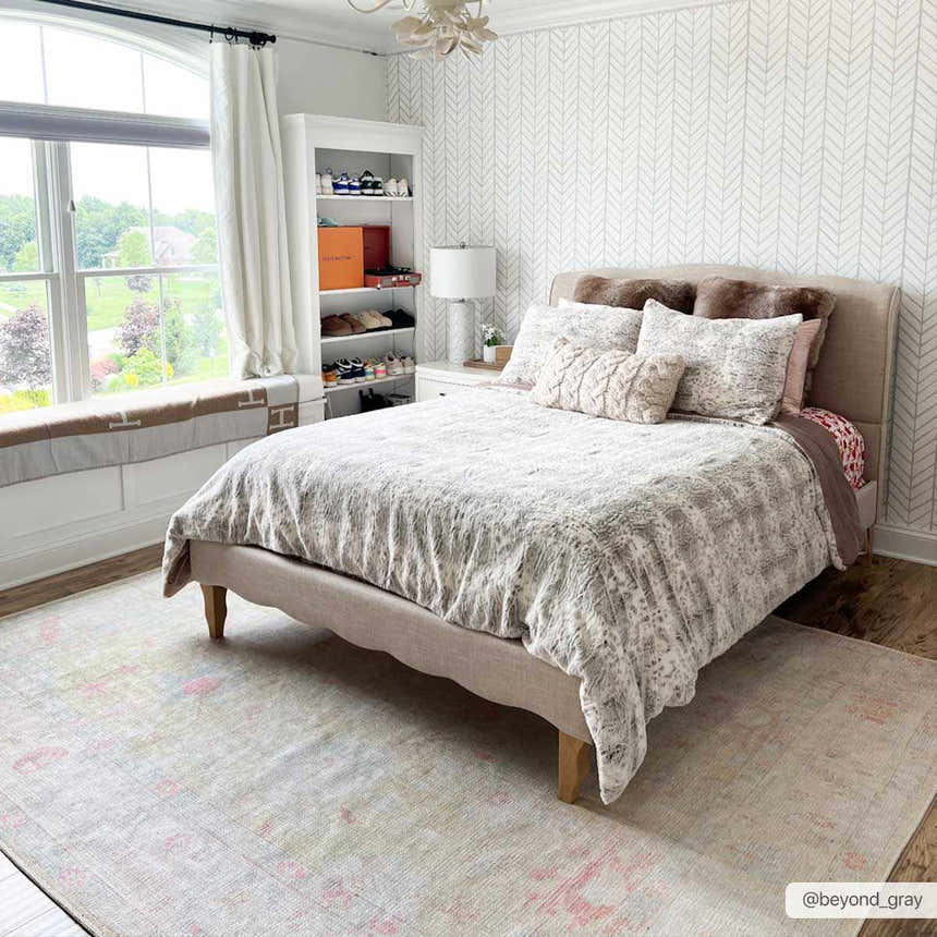 Bedroom scene with a Bozkurt Boutique Washable Rug, light gray walls, neutral bedding, and a window seat. Roomscene-Rectangle
