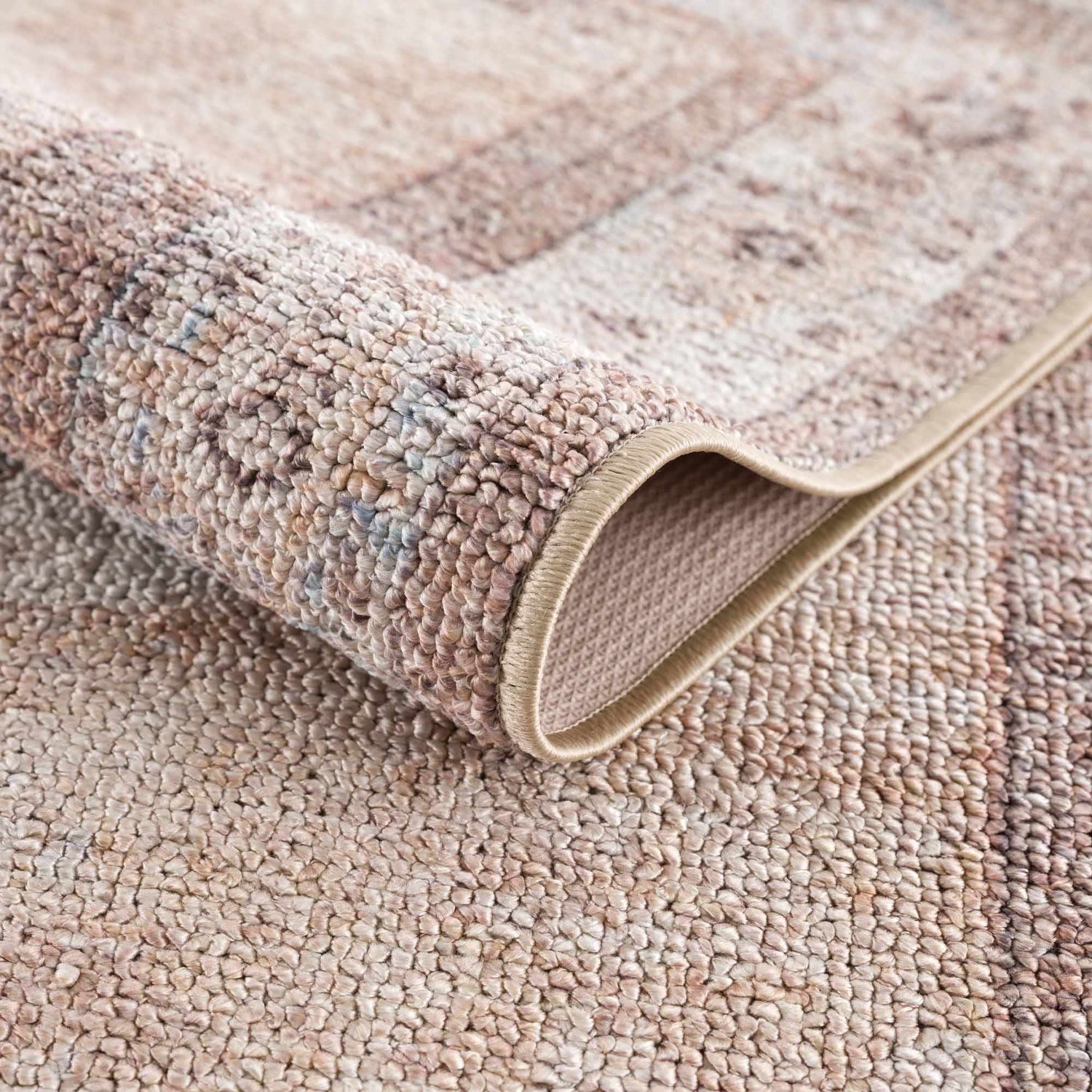 Close-up of the tan Analu Non-Slip Washable Rug showing its texture, backing, and traditional pattern. Fold