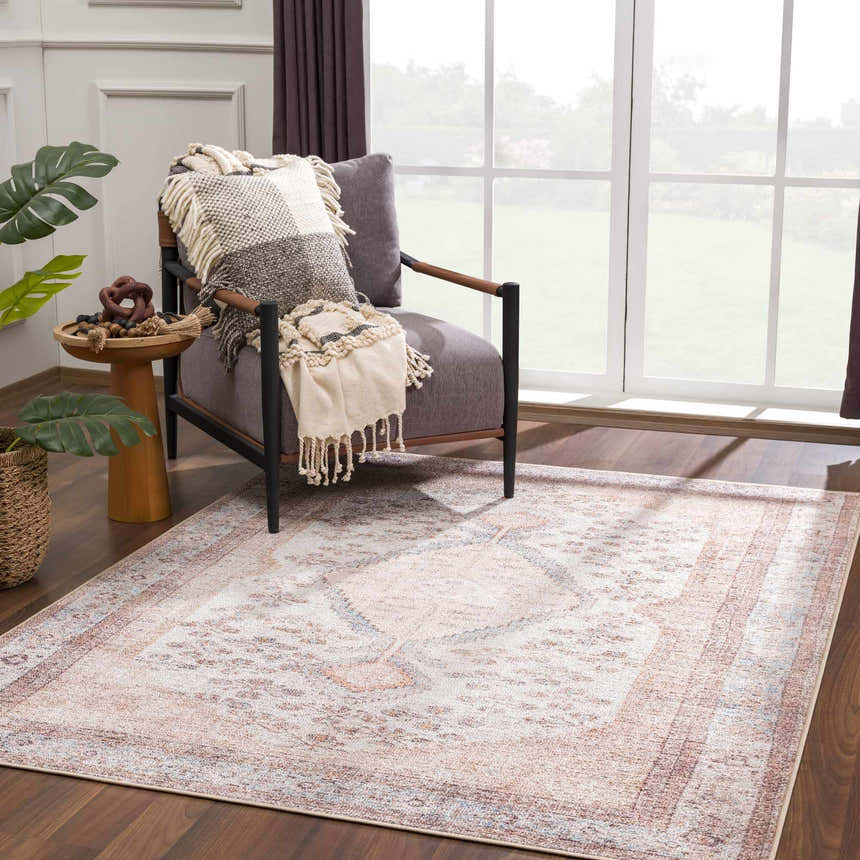 Living room scene with a rustic vintage Analu Non-Slip Washable Rug, gray chair, and side table with plant. Brown, tan, and light blue tones. Roomscene-Rectangle