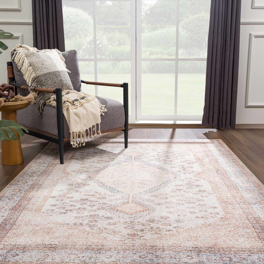 Living room scene with a tan and light blue Analu Non-Slip Washable Rug, gray armchair, and large window. Roomscene-Rectangle
