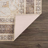 Close-up of the Albas Washable Area Rug showing its traditional vintage pattern, dark brown, light brown, and light blue colors. Fold