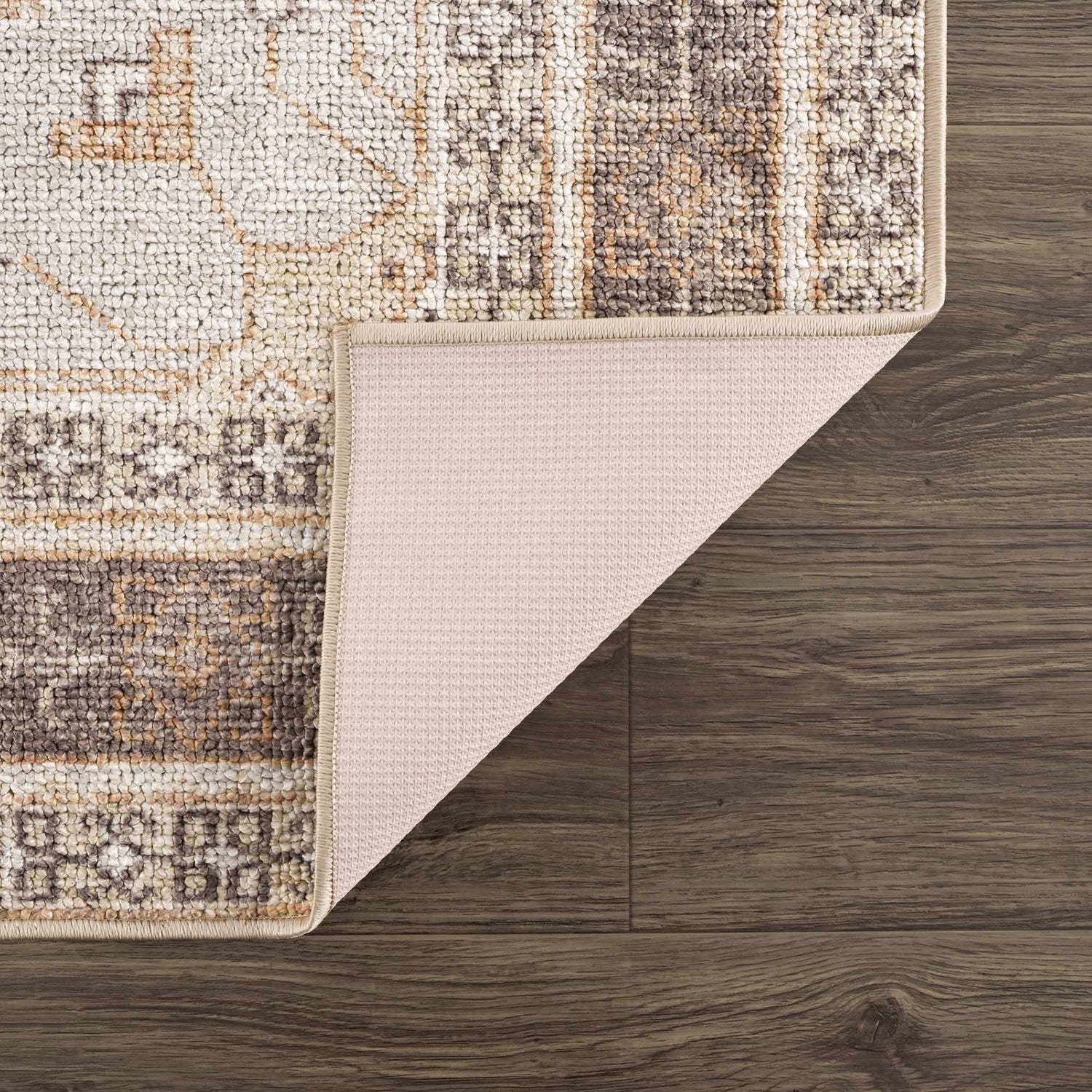 Close-up of the Albas Washable Area Rug showing its traditional vintage pattern, dark brown, light brown, and light blue colors. Fold