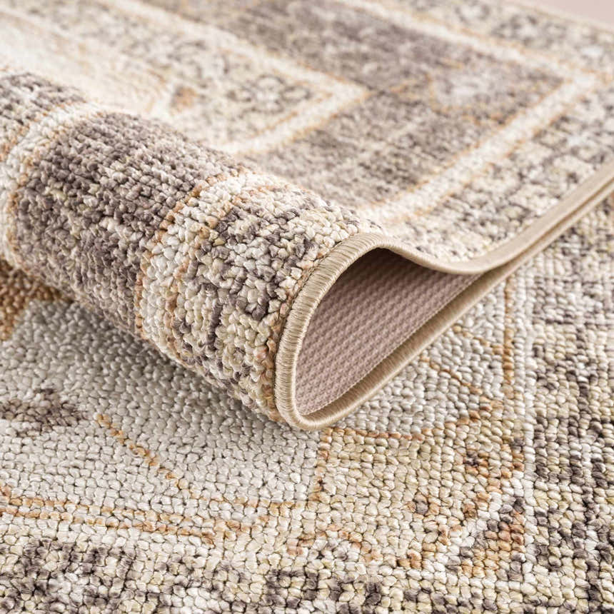 Close-up of the Albas Washable Area Rug showing its traditional vintage pattern and texture in light brown and dark brown tones. Fold