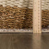Close up of the Albas Washable Area Rug showing the light brown, dark brown, and light blue colors and the rug's texture. Pile