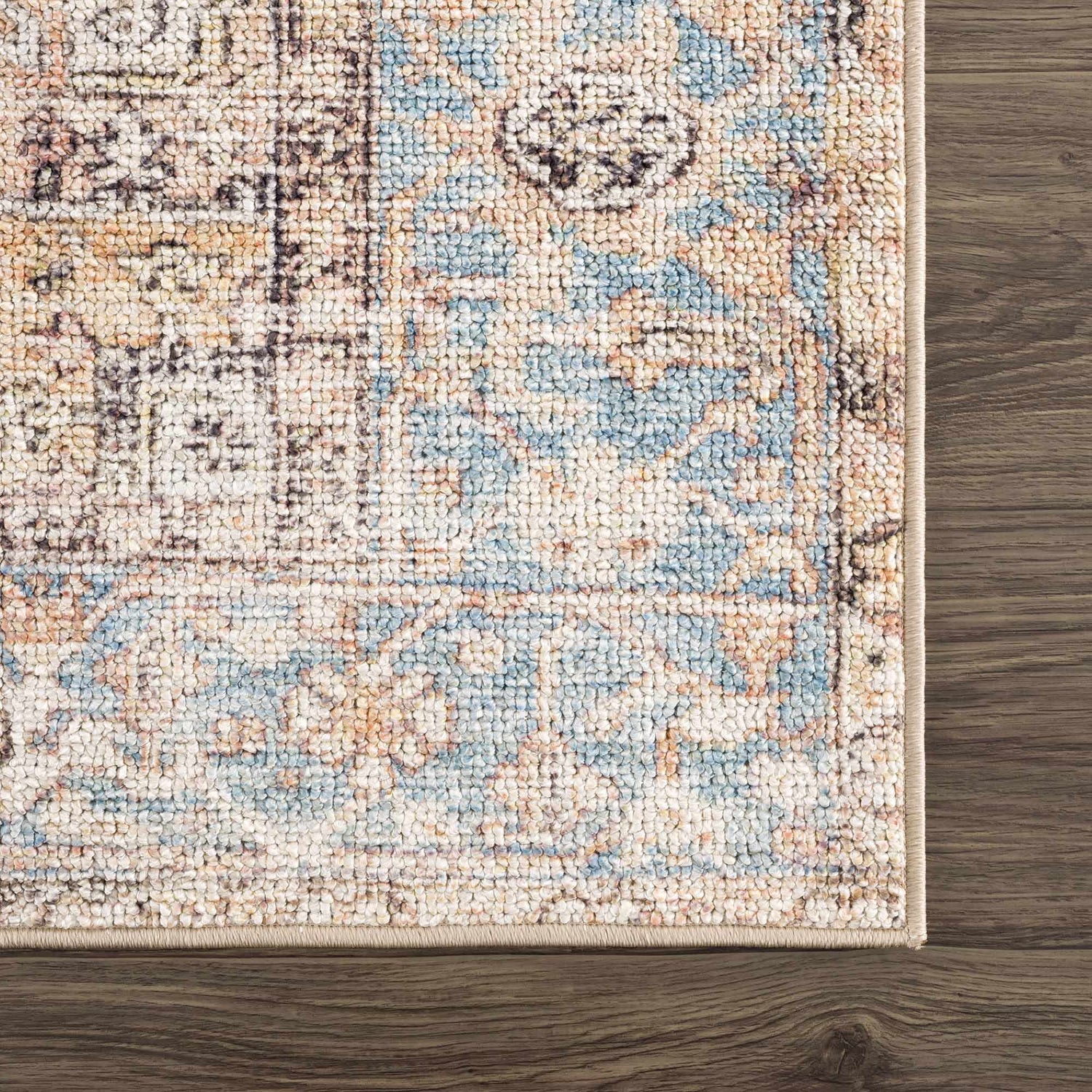 Close up of Beck Peach Washable Area Rug showing beige, blue, and brown traditional pattern and soft texture. Swatch