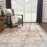 Living room scene with a Beck Peach Washable Area Rug, gray chair with throw, side table, and natural light. Roomscene-Rectangle