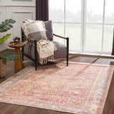 Cozy reading nook with a peach traditional vintage Anshu Washable Area Rug, gray chair, and natural light. Roomscene-Rectangle