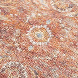 Close-up of the Anshu Peach Washable Area Rug showing its traditional vintage design, beige, blue, and burgundy colors. Texture