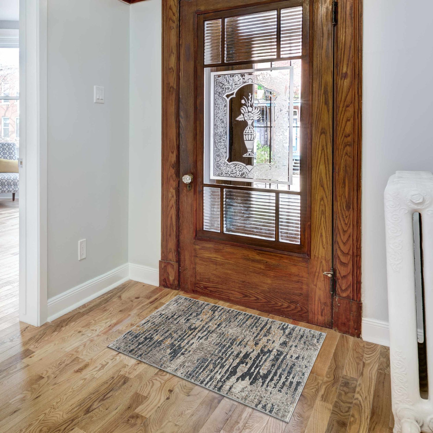 Entryway with wood floors and a Sywell Luxe Fringe Rug in beige, blue, and charcoal. Roomscene-Rectangle
