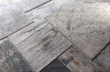Close-up of Sywell Luxe Fringe Rug in beige, blue, and charcoal. Contemporary polyester rug with a distressed, vintage-inspired design. Styleshot