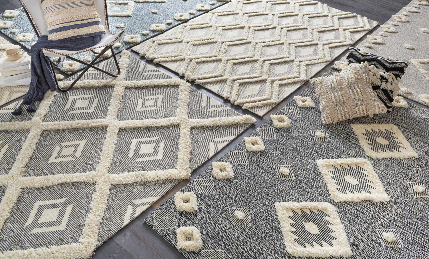 Close-up of multiple Imnaha Area Rugs in black, charcoal, and cream wool with bohemian, farmhouse designs. Styleshot