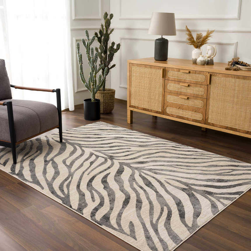 Living room with a gray armchair and wood cabinet featuring the Gray Ecorse Zebra Print Area Rug. Roomscene-Rectangle