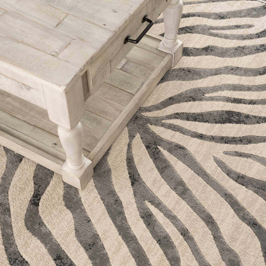 Close-up of the Gray Ecorse Zebra Print Area Rug featuring black, charcoal, and light beige tones with a textured, machine-woven design. Styleshot