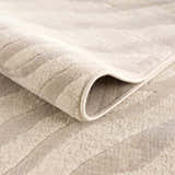 Close-up of the Beige Manteca Zebra Print Area Rug showing its soft texture, beige and light gray pattern, and bound edge. Fold
