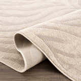Close-up of the Beige Manteca Zebra Print Area Rug showing its light beige color, soft texture, and machine-woven construction. Fold