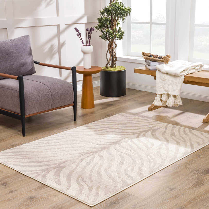 Living room scene with a Beige Manteca Zebra Print Area Rug, gray chair, wood accents, and natural light. Roomscene-Rectangle