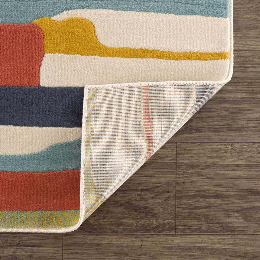 Close-up of the Southfields Colorful Modern Area Carpet showing the aqua, charcoal, orange, and beige abstract design. Fold
