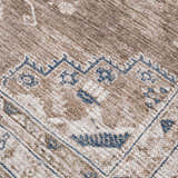 Close-up of the Baltinglass Washable Rug. Beige and brown rug with a traditional blue and cream pattern. Texture