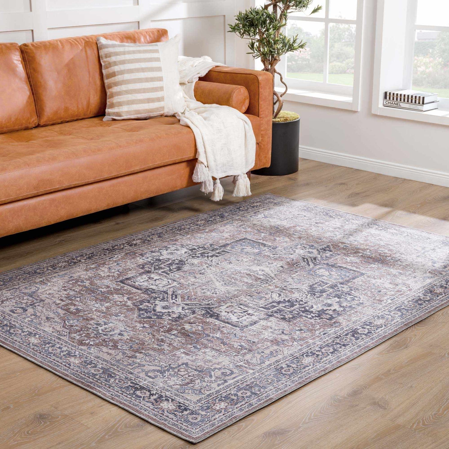 Living room with brown leather sofa and Abner Washable Area Rug in brown, charcoal, and denim. Traditional style. Roomscene-Rectangle