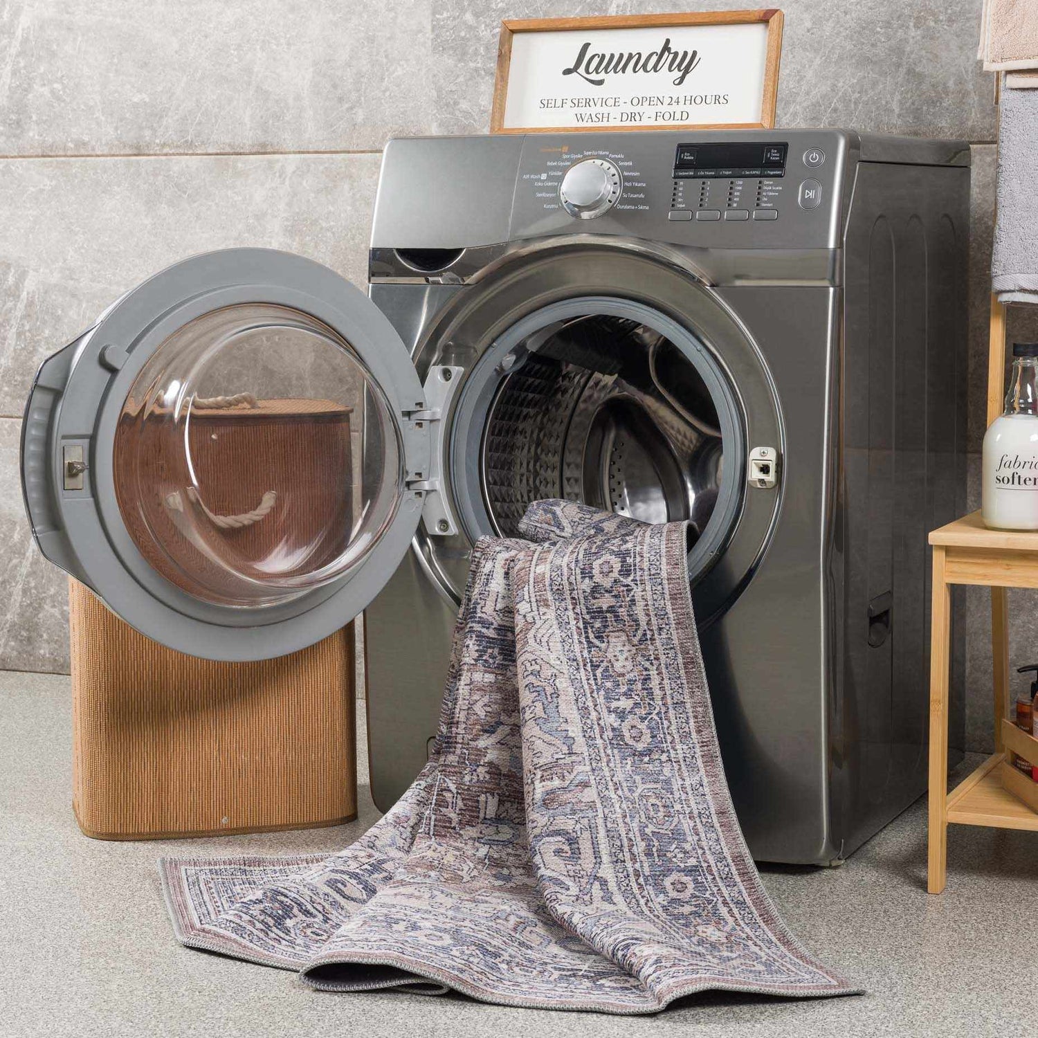 Abner Washable Area Rug in a laundry room, partially inside a washing machine. Brown, denim, and ivory traditional rug. Washing-Machine
