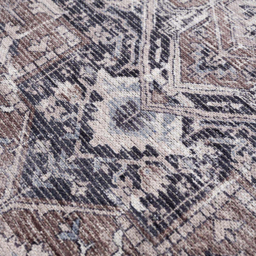 Close-up of the Abner Washable Area Rug, showcasing its traditional pattern and texture in brown, charcoal, and denim hues. Texture