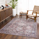Living room scene with a Viho Vintage Flat Pile Washable Rug in brown, blue, and white, wooden cabinet, and woven chairs. Roomscene-Rectangle