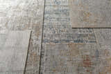 Close-up of the textured Dowell Luxe Area Rug showing its brown, gray, off-white, and dark blue color palette. Styleshot