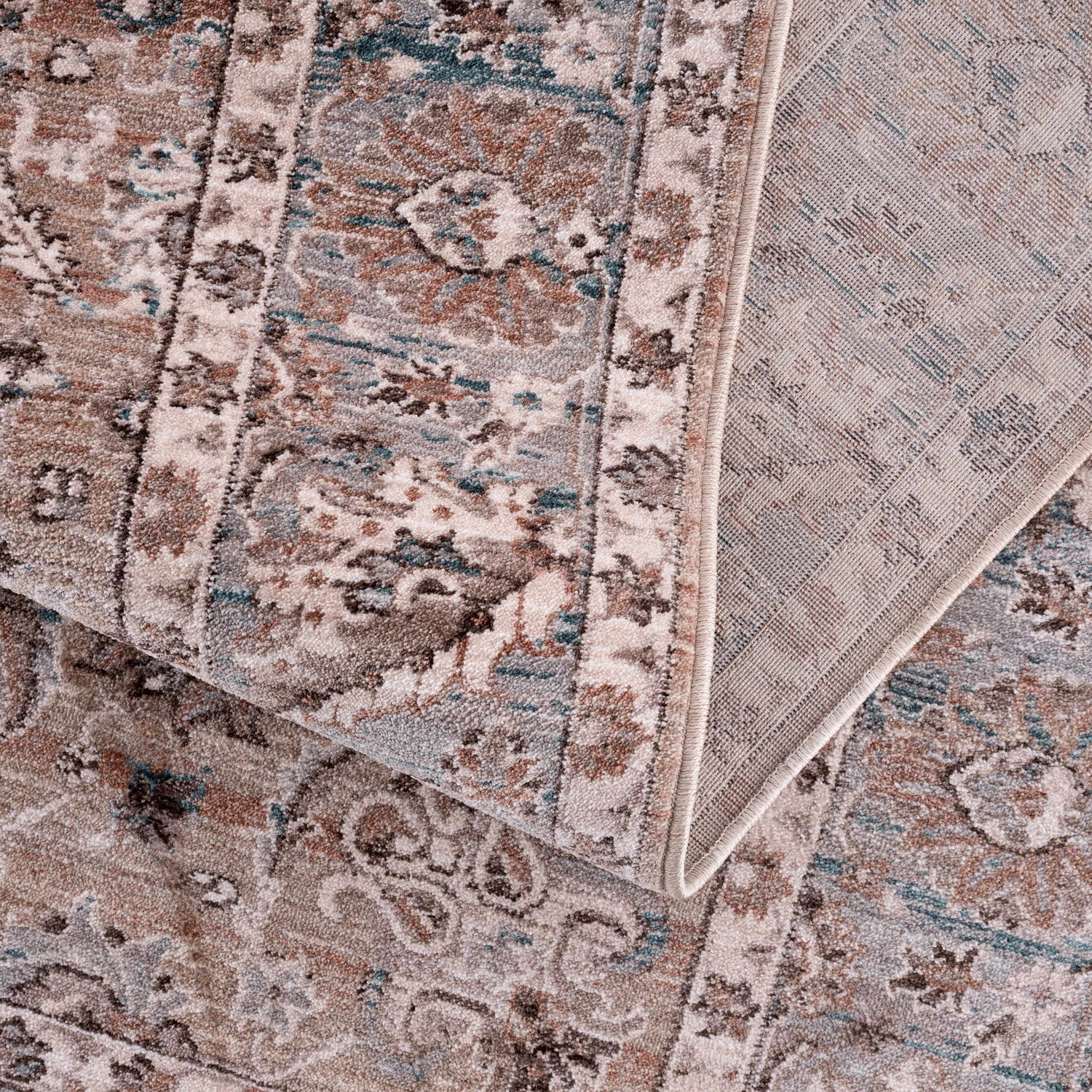Close-up of the Civankan Area Rug - Clearance, showcasing its traditional oriental pattern in brick red, denim, and ivory hues. Fold