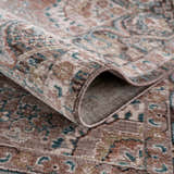 Close-up of the rolled-up Baychester Brown Area Rug, showing its traditional pattern, brown, pink, and teal colors. Fold