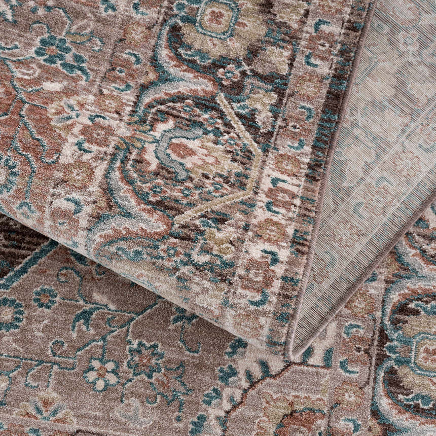 Close-up of the Baychester Brown Area Rug showing its traditional oriental pattern, dark brown, denim, and dusty pink colors. Fold