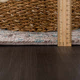 Close-up of the edge of the Baychester Brown Area Rug showing its texture, colors, and thickness with a ruler. Pile