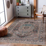 Living room scene with a Baychester Brown Area Rug, gray dresser, woven chair, and brown leather pouf. Roomscene-Rectangle