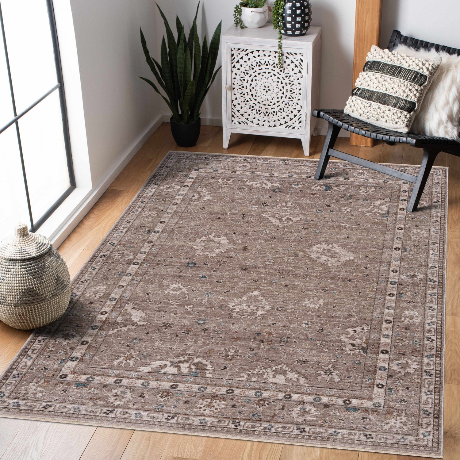 Living room scene with the brown, traditional Bolitoc Area Rug, white cabinet, and black chair on wood floor. Roomscene-Rectangle