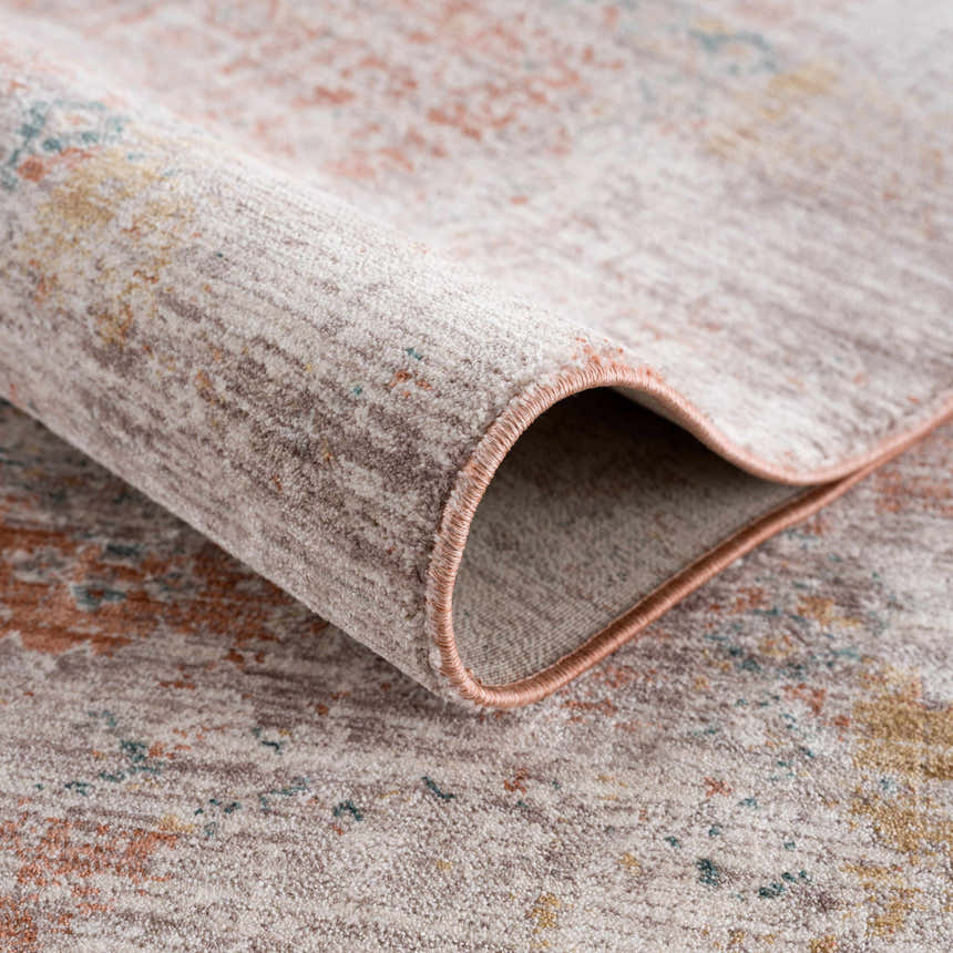 Close up of the rolled edge of the Casta Area Rug, showing beachhouse, beige, and garnet colors. Fold