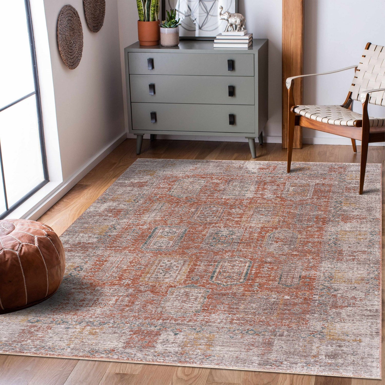 Living room scene with a faded orange Casta Area Rug, gray dresser, and leather pouf. Roomscene-Rectangle
