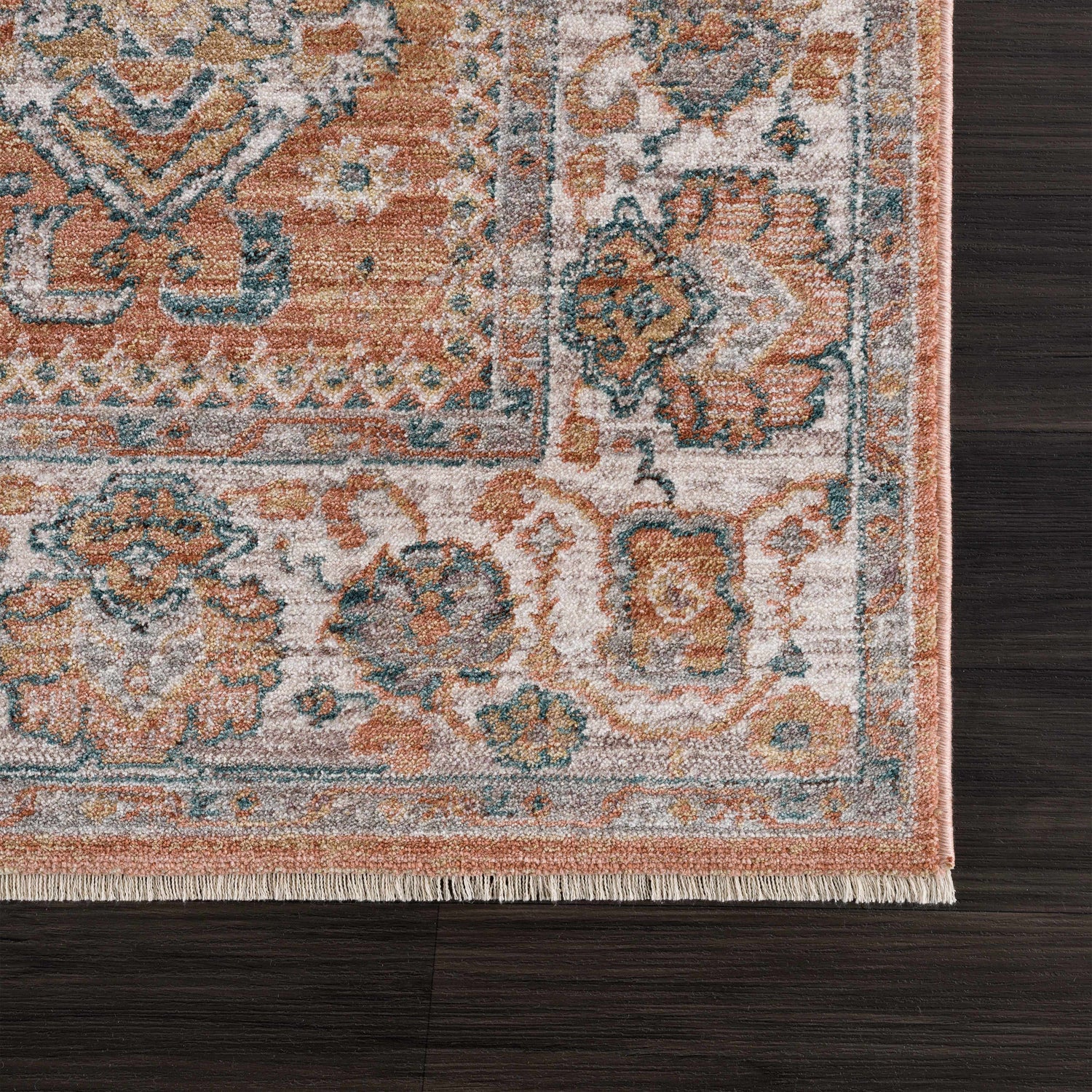 Close-up of Cayla Area Rug on dark wood floor. Traditional design in bone, clay, garnet, light brown, and taupe. Swatch