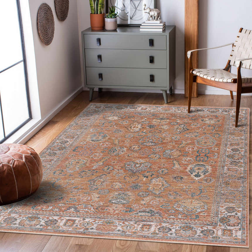 Living room scene with Cayla Area Rug in bone, clay, and garnet. Farmhouse style with grey dresser, leather pouf, and wood chair. Roomscene-Rectangle