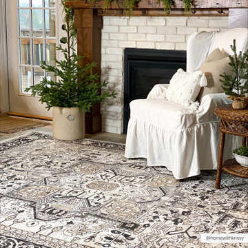 Living room scene with a Cabacungan Washable Area Rug in black, gray, and beige under a white chair and near a fireplace. Roomscene-Rectangle
