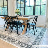 Dining room with wood table, black chairs, and Cabacungan Washable Area Rug in black, gray, and beige. Roomscene-Rectangle