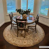 Dining room with round wood table, chairs, and Canadensis Traditional Turkish Rug in light beige and brown. Roomscene-Round