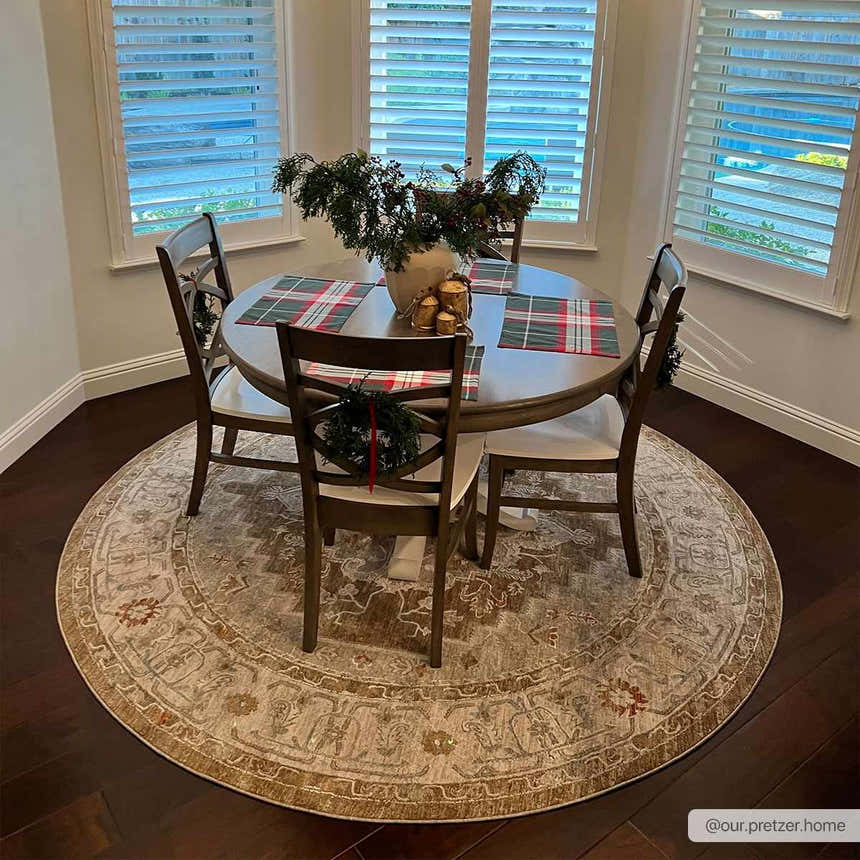 Dining room with round wood table, chairs, and Canadensis Traditional Turkish Rug in light beige and brown. Roomscene-Round