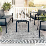 Farmhouse porch with gray Cheverly Area Rug, black patio furniture, and white railing overlooking a field. Roomscene-Rectangle