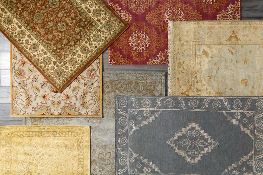 Overhead shot of several Pirtleville Area Rugs in various colors and patterns on a wood floor. Styleshot