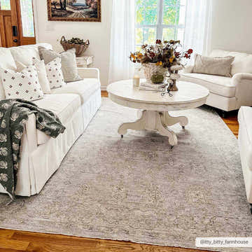 Farmhouse living room with white sofas and the Coby Teal Avant Garde area rug under a round coffee table. Roomscene-Rectangle