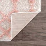 Close-up of the plush Darva Pink Area Carpet showing its pink geometric pattern, texture, and backing. Fold