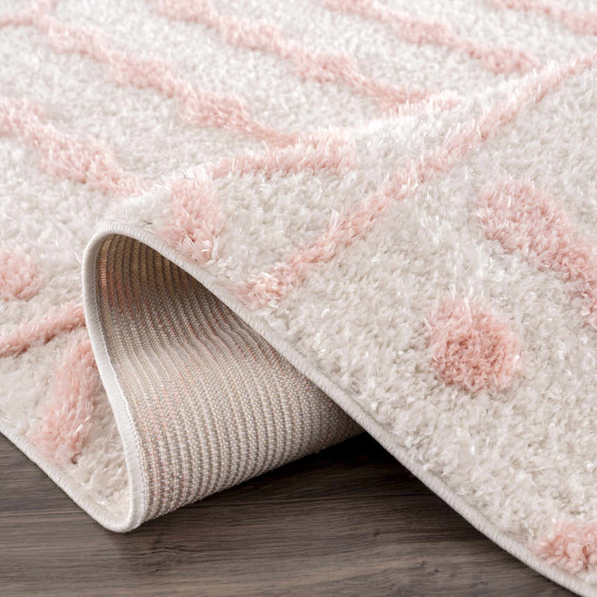 Close-up of the plush Darva Pink Area Carpet, featuring a geometric shag design and woven backing. Fold